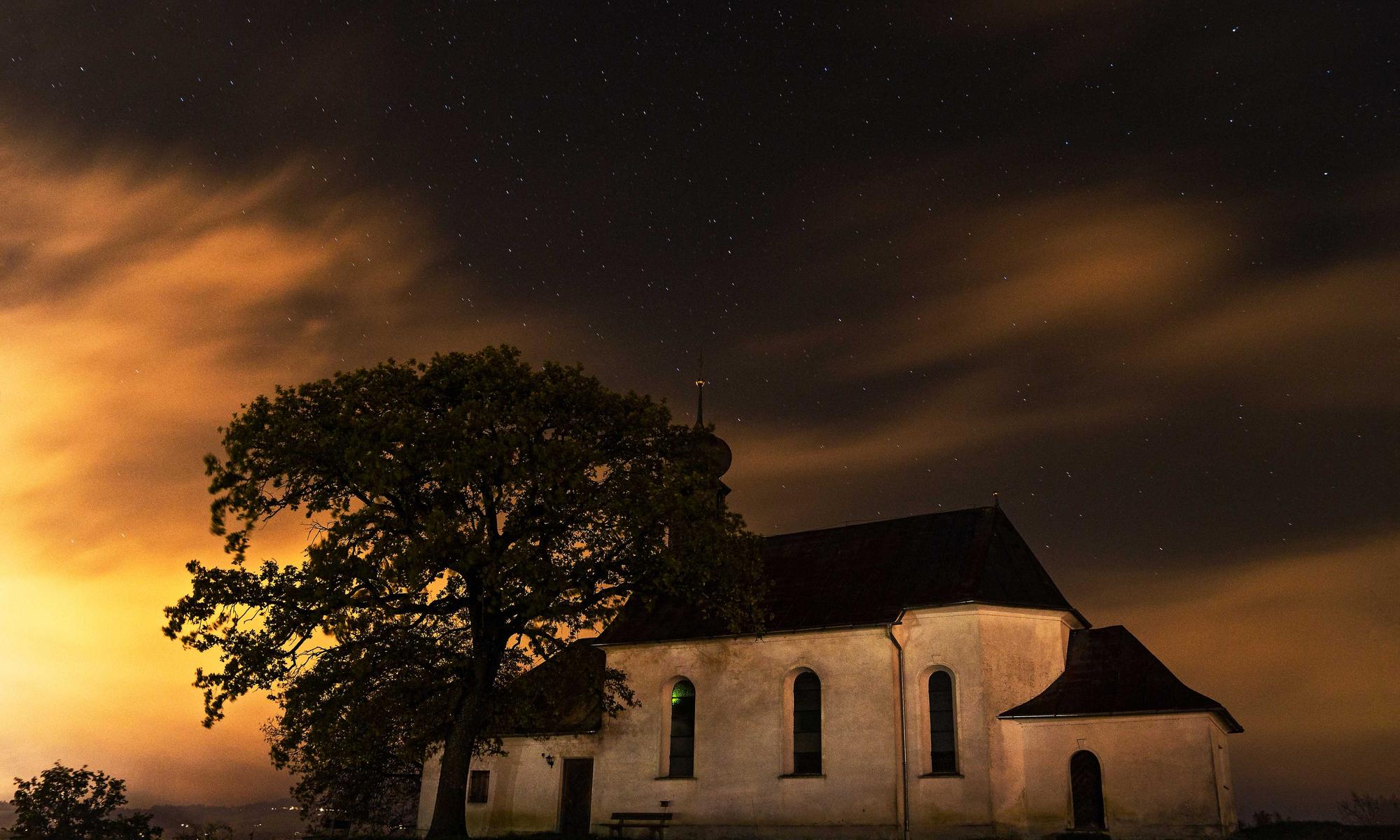 Kapelle unter einem Baum bei Sonnenuntergang